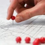 hand placing a location pin on a map