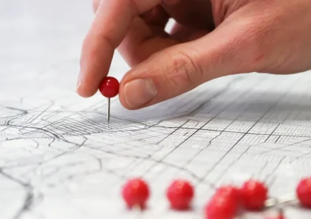 hand placing a location pin on a map