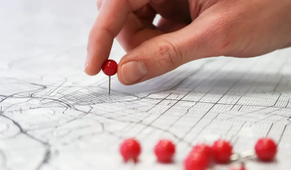 hand placing a location pin on a map