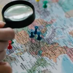 magnifying glass over a map with location pins