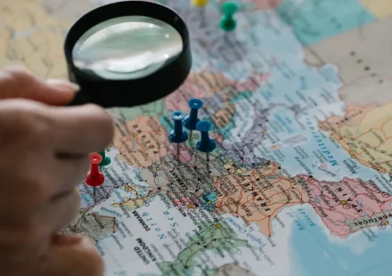 magnifying glass over a map with location pins