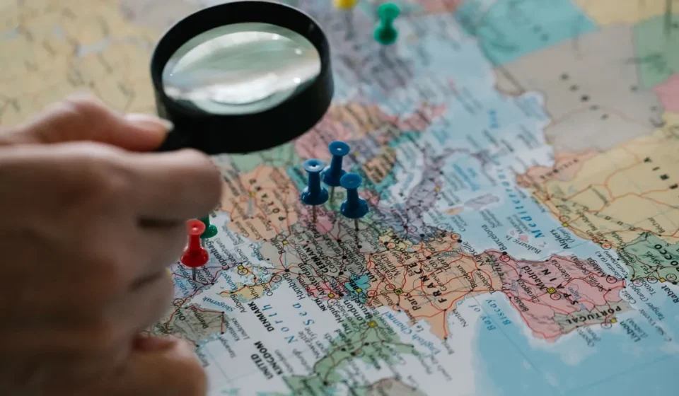 magnifying glass over a map with location pins
